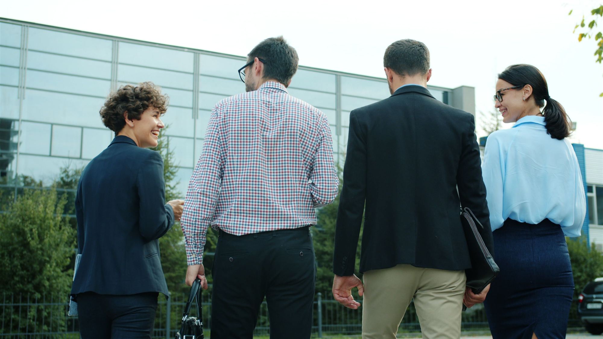 Corporate delegation walking together outside an office building